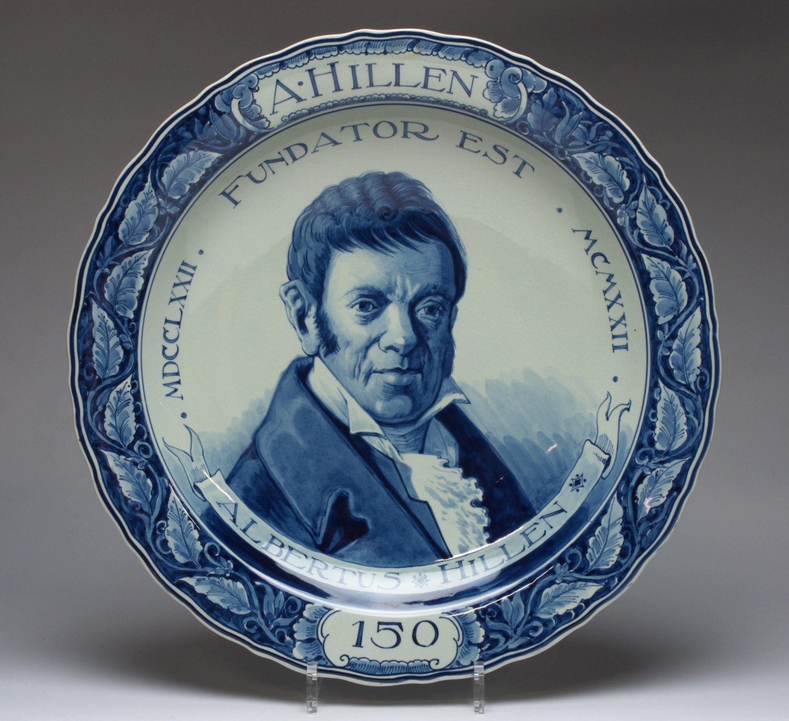 Delfts-blauwe gedenkschotel voor het 150-jarig jubileum, met portret van Albertus Hillen — ‘Fundator Est’.